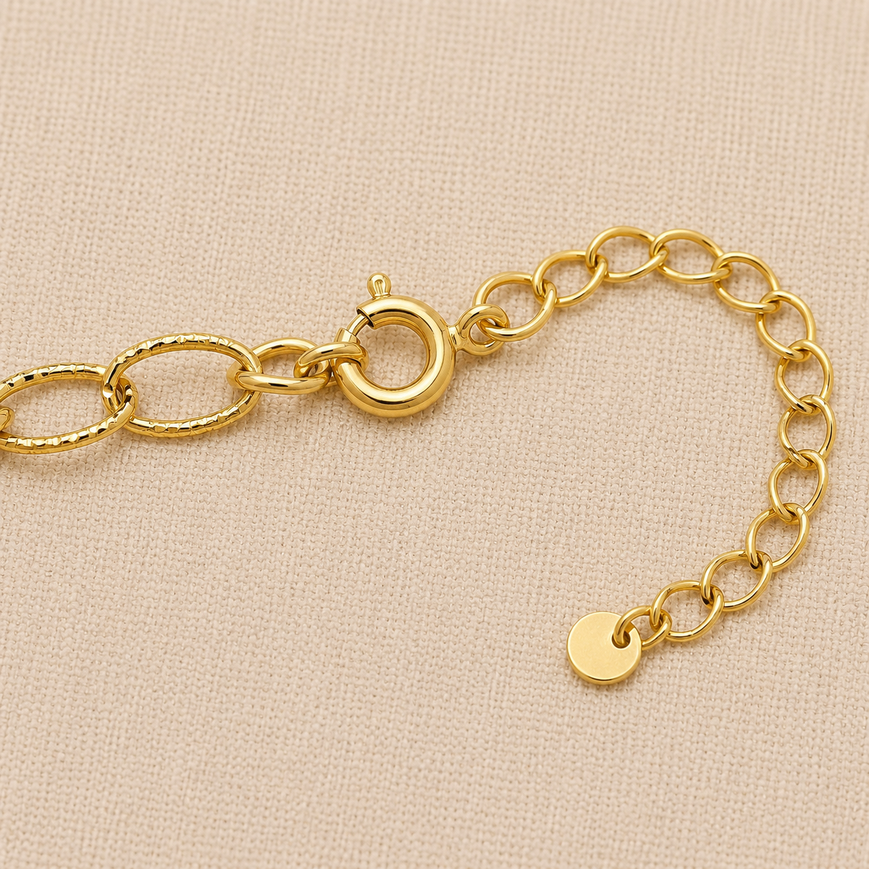 Ocean-inspired gold charm bracelet with starfish and seashell charms on cream linen background.